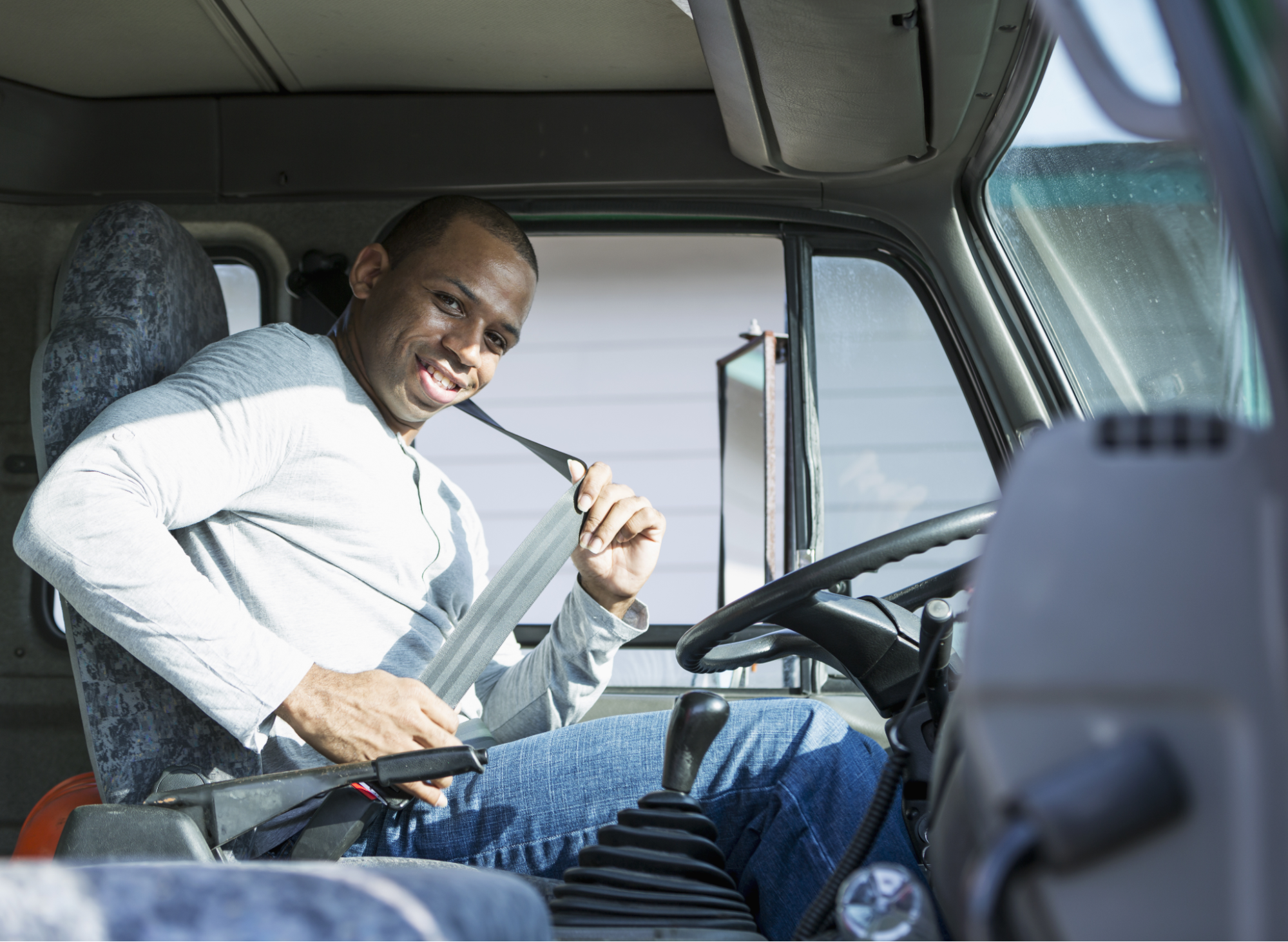 truck driver putting seatbelt on