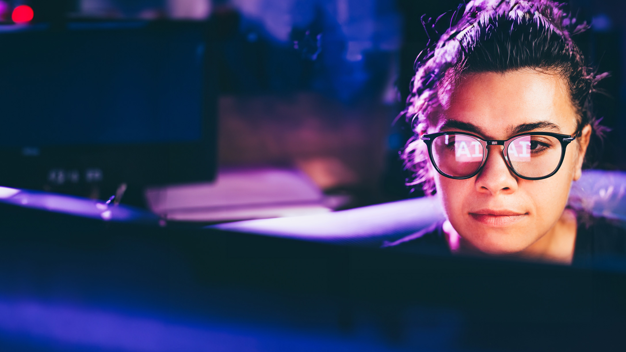 Person looking at a computer screen with the refleciton in their glasses