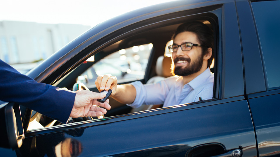 person in car taking keys 