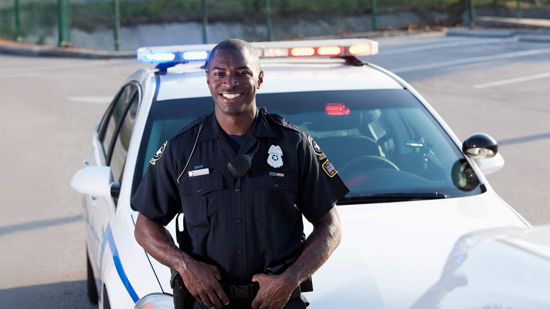 police officer standing in front of a cruiser