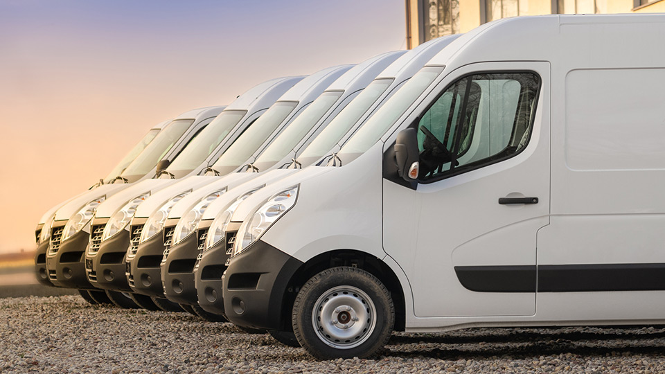 A lineup of white trucks in a parking lot