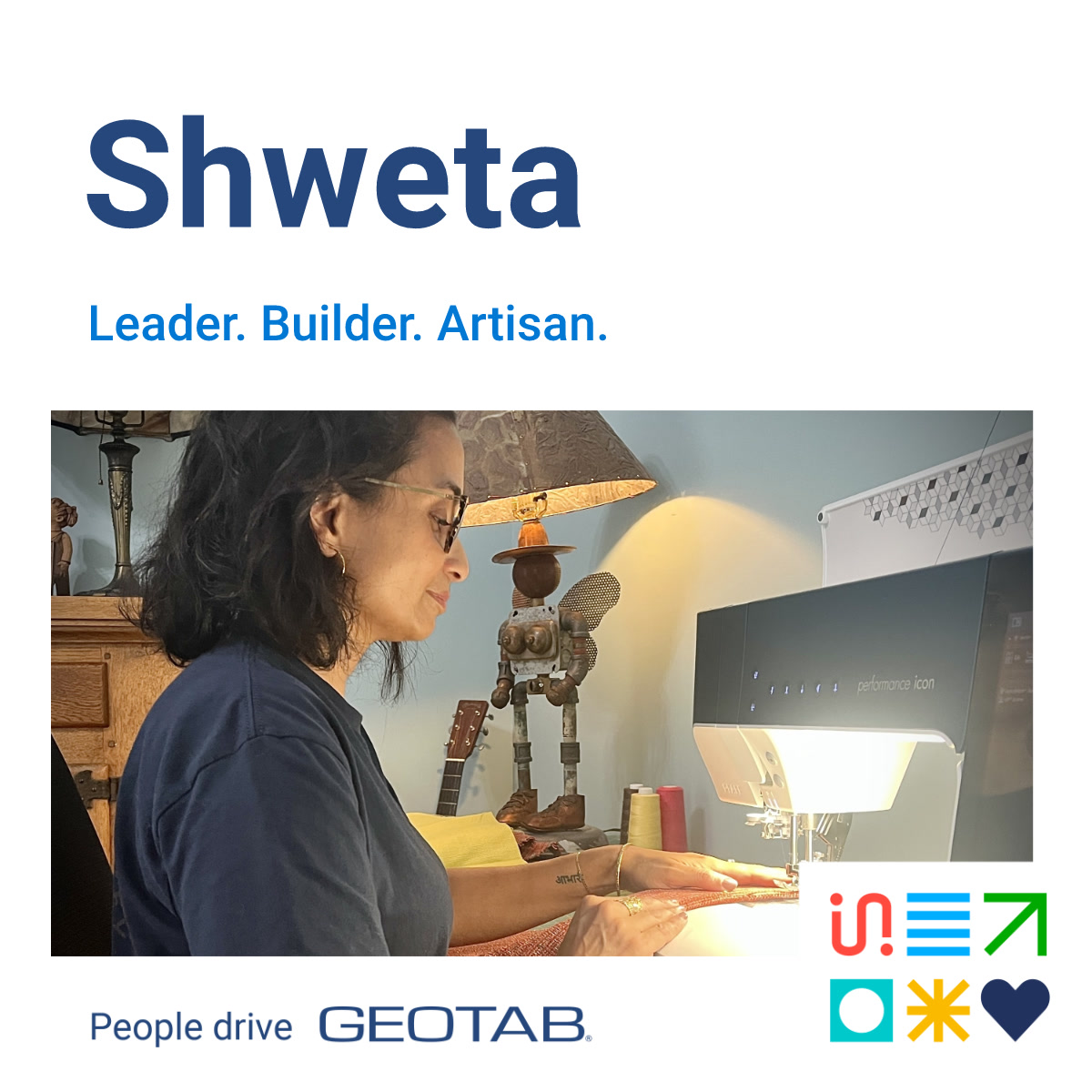 Shweta sitting a desk using a sewing machine