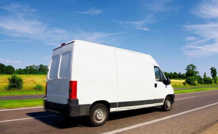  Weißer Transporter fährt auf einer Straße bei blauem Himmel