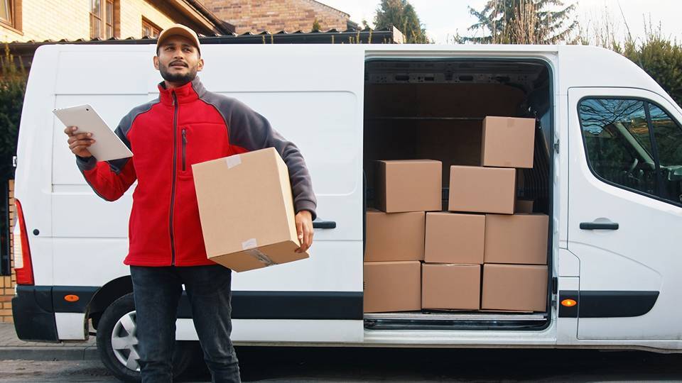 man delivering package using tablet