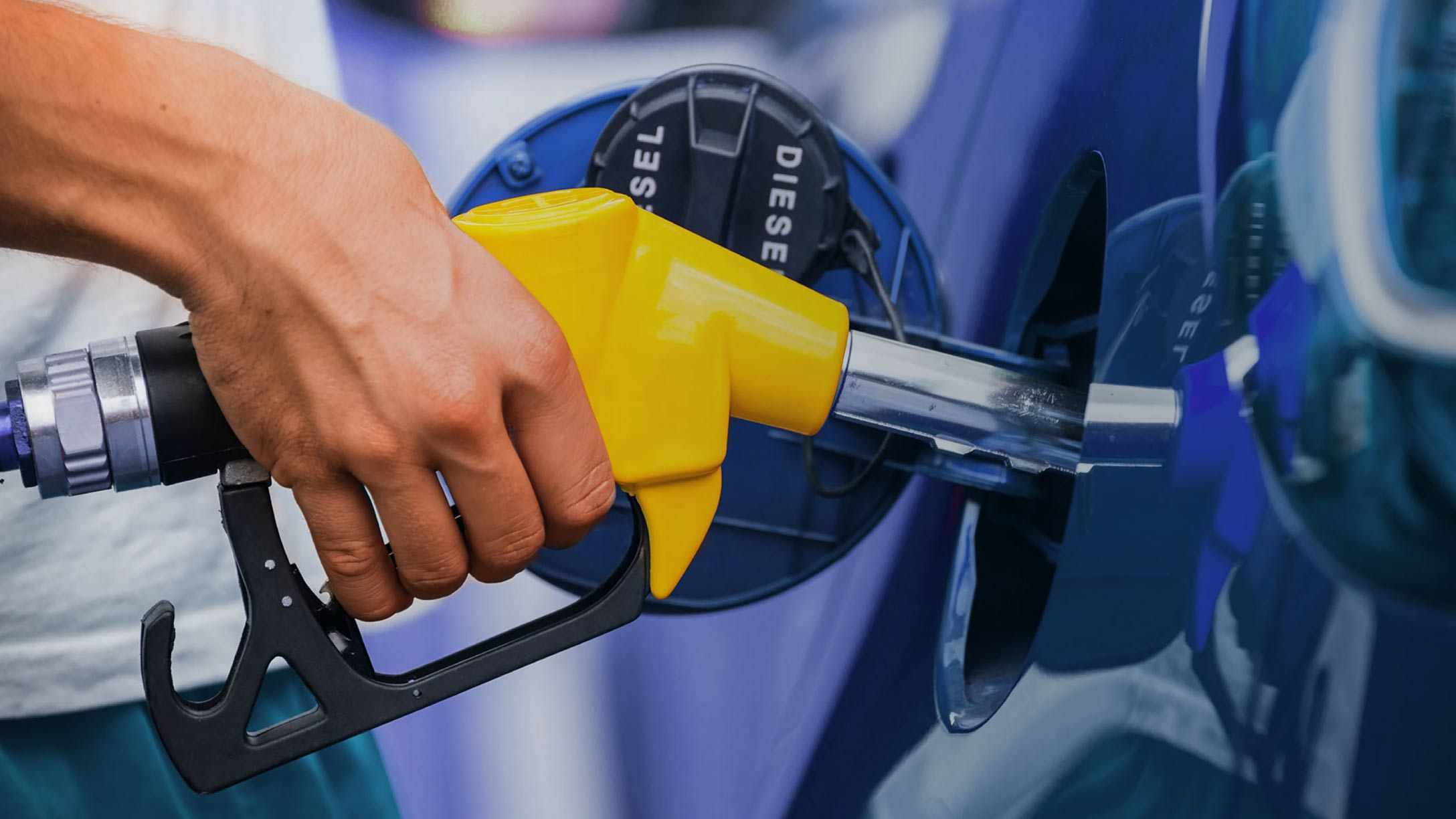 Primer plano de una mano sosteniendo una manguera de combustible diesel, representando la gestión eficiente del combustible en flotas.