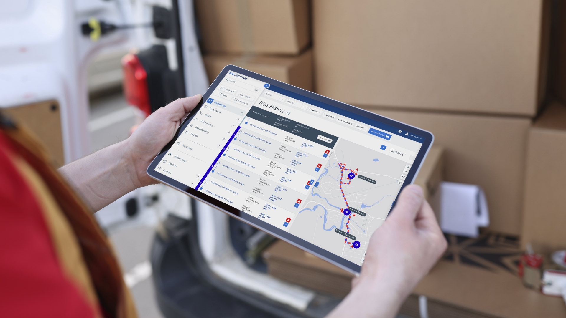 Un técnico de servicios de campo sostiene una tableta mostrando un mapa con rutas optimizadas y el historial de viajes de vehículos, ilustrando cómo la telemática mejora la eficiencia operativa.