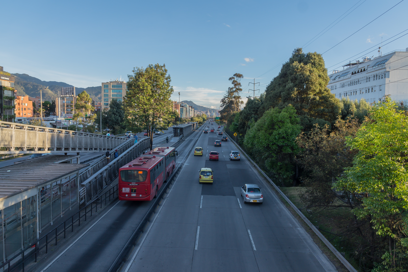 Imagen de varios camiones circulando por una carretera, resaltando elementos visuales como íconos de GPS y señales de datos. La escena transmite el uso de tecnología telemática en tiempo real para monitorear y gestionar flotas de manera eficiente.