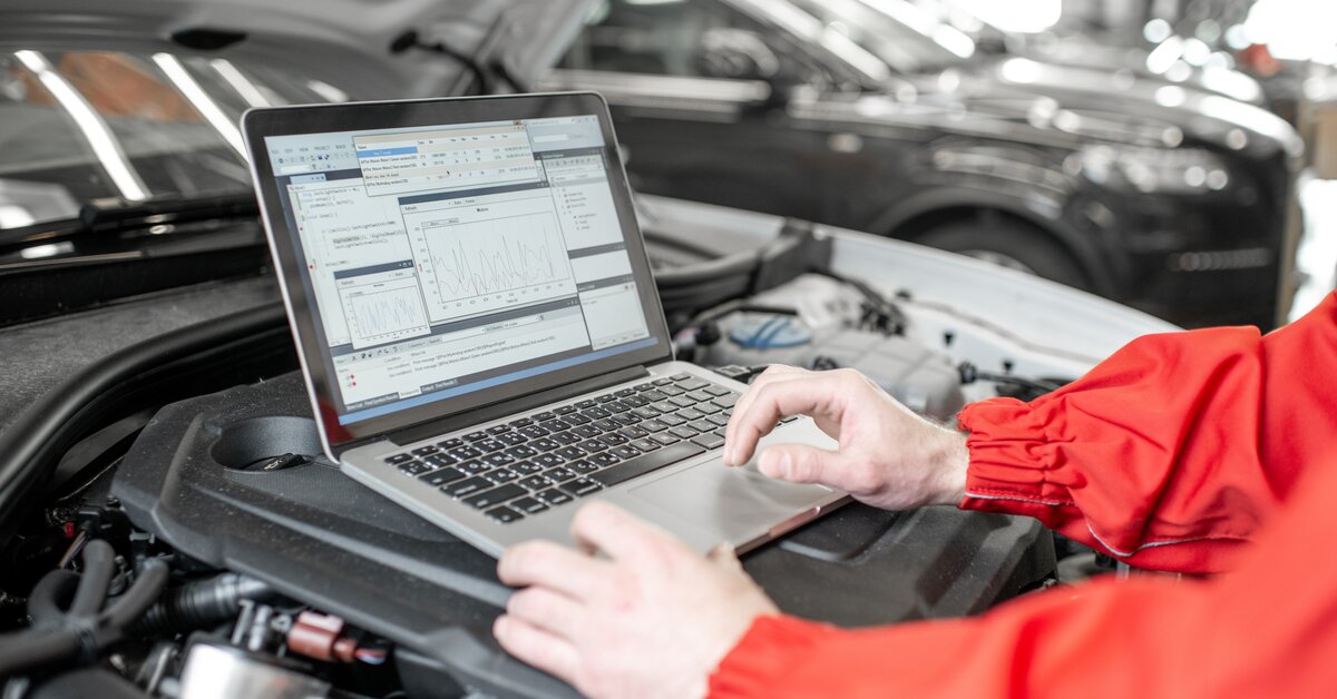  Mécanicien inspectant un module de commande moteur (ECM) sous un capot