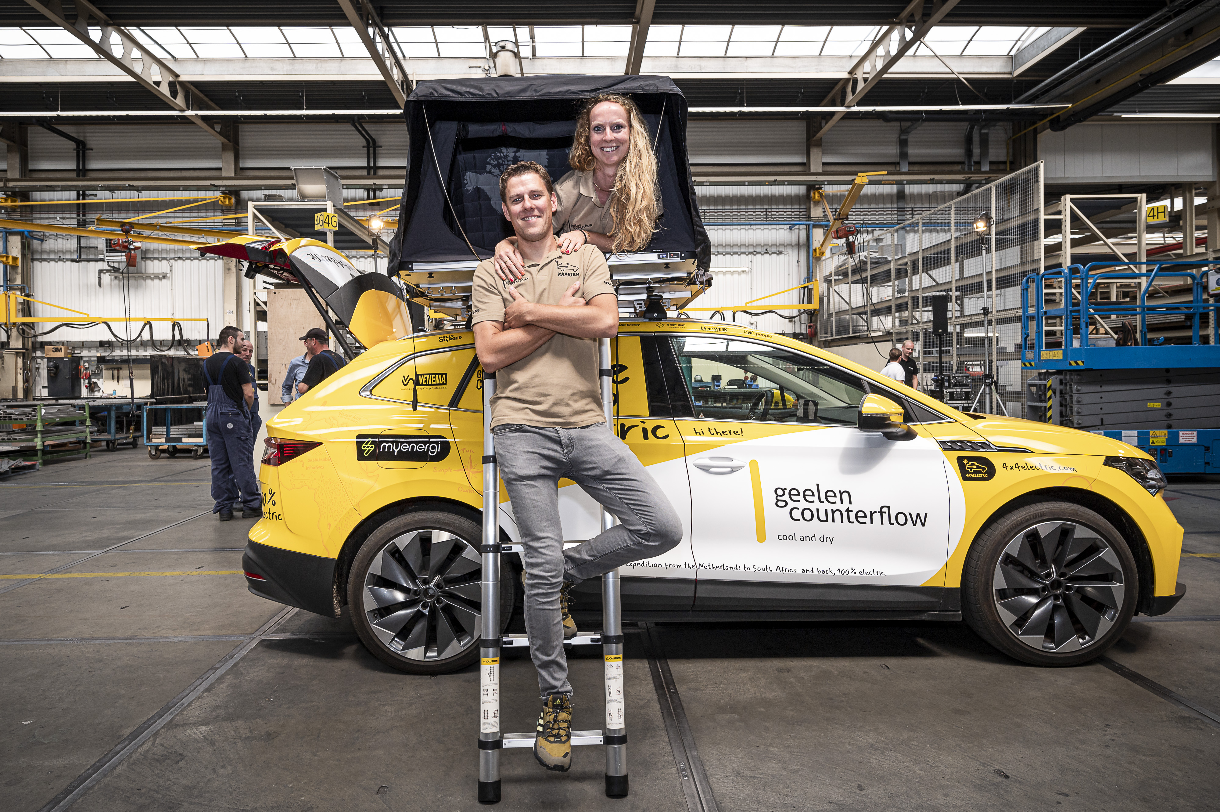 Un couple devant un véhicule électrique