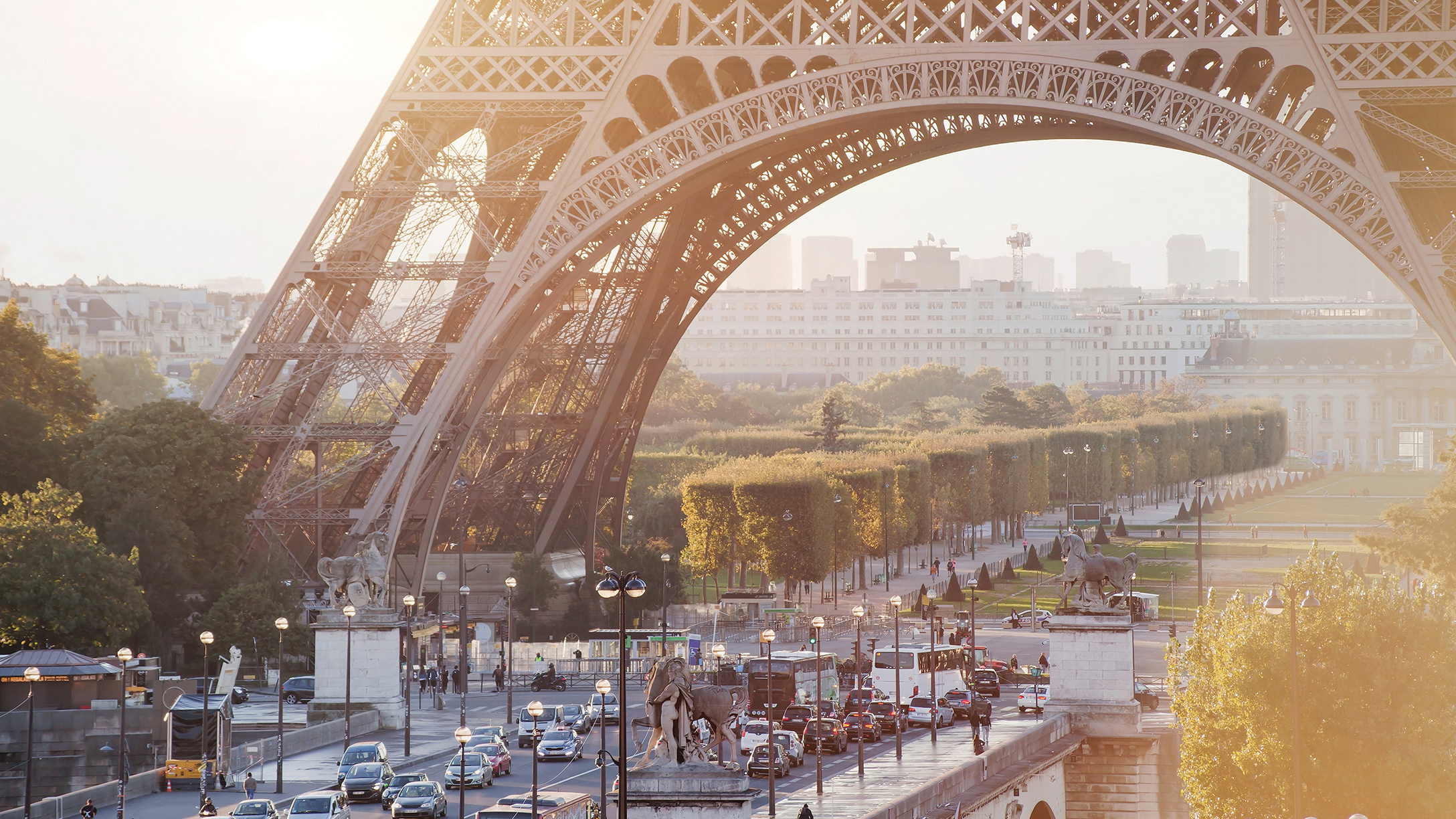 Particolare del traffico parigino con autobus, bici e auto sotto alla Tour Eiffel