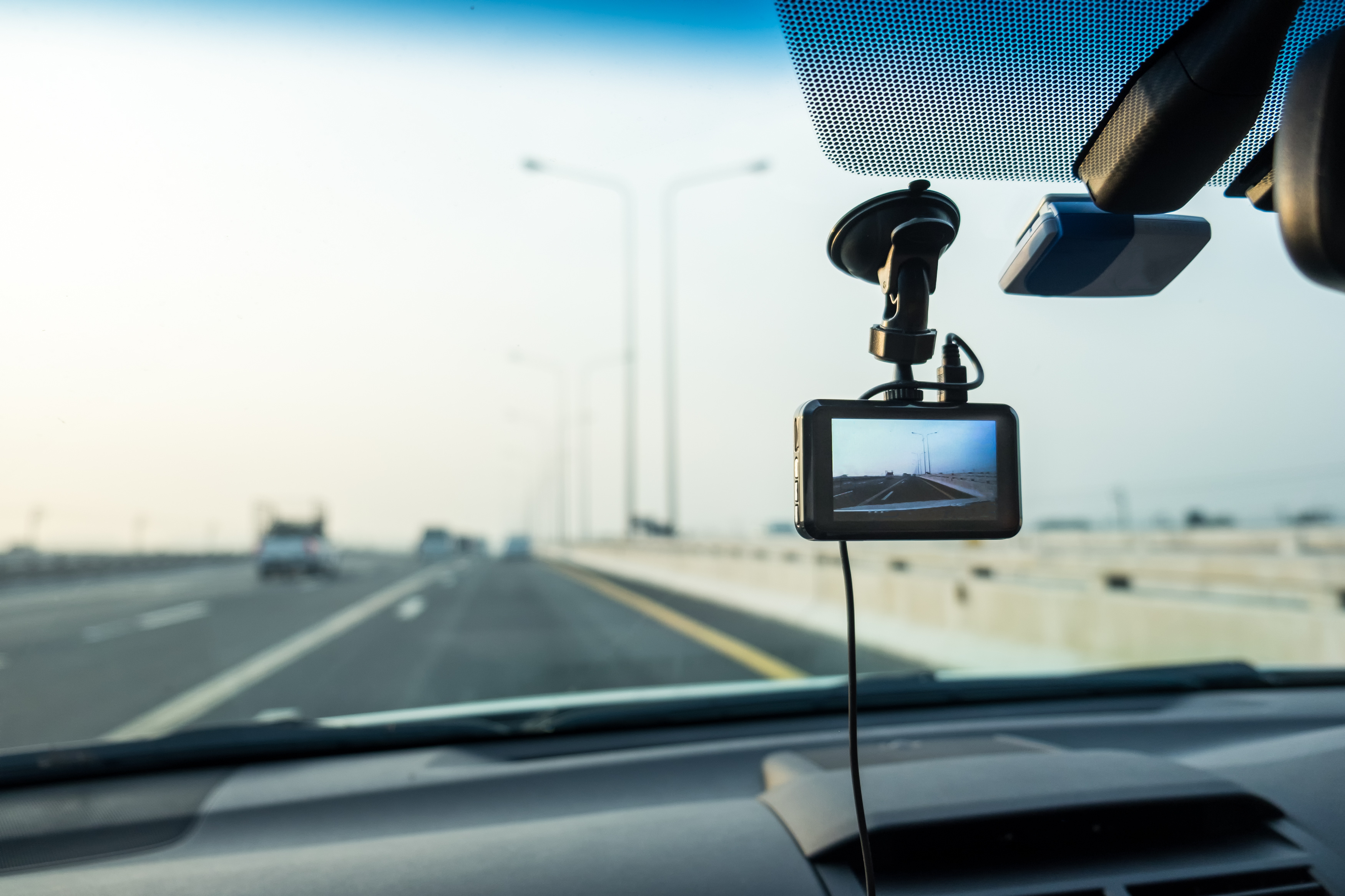 Autostrada fotografata dall'abitacolo con al centro una dash cam