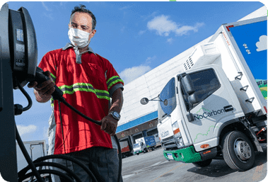 Um homem colocando eu caminhao eletrico para carregar