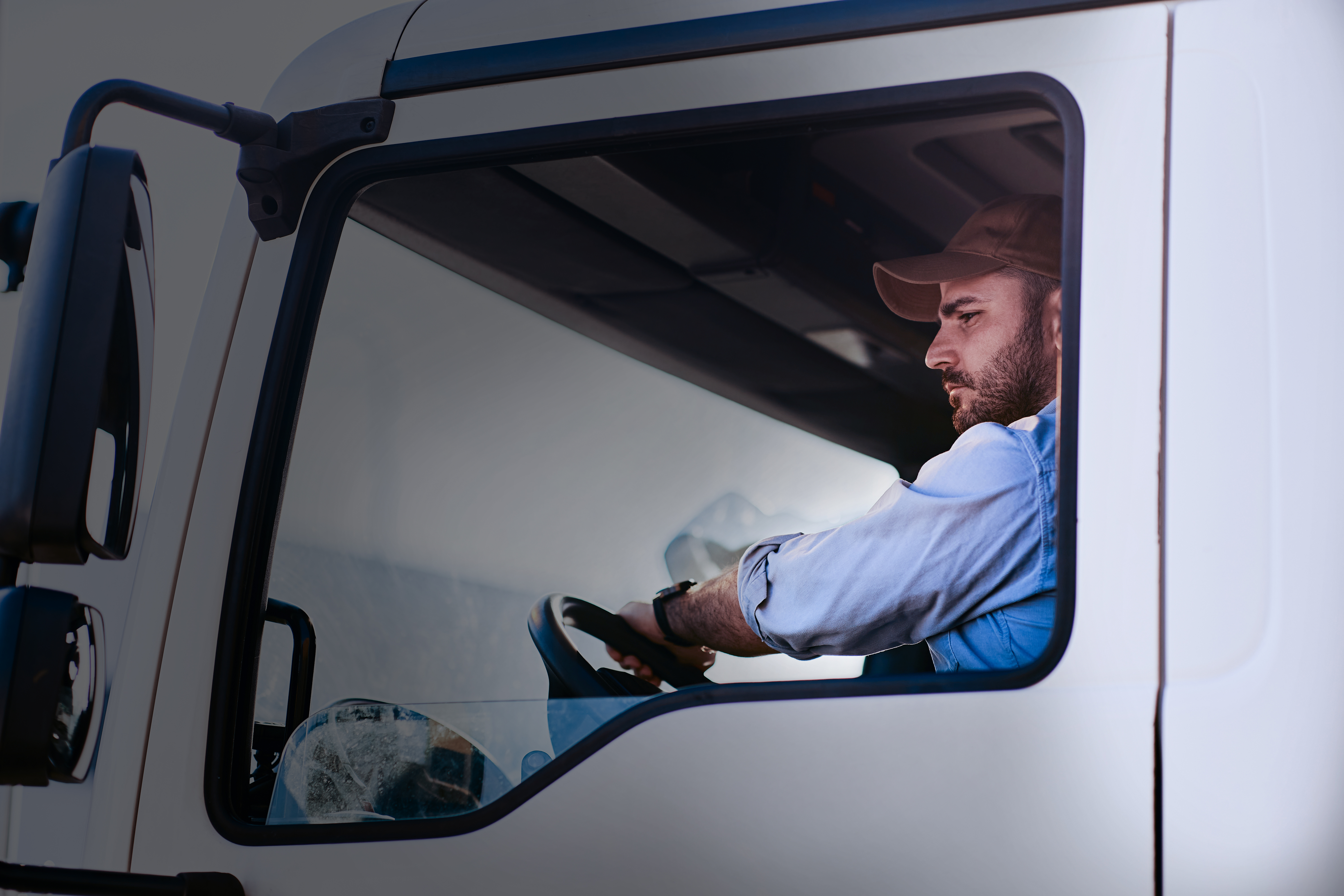 Motorista profissional dirigindo caminhão, representando a importância do monitoramento de motoristas de frota para segurança e eficiência operacional