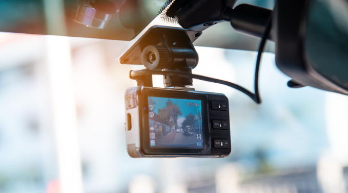 Imagem de câmera veicular de videomonitoramento instalada no para-brisa de um carro, capturando imagens da estrada em tempo real.