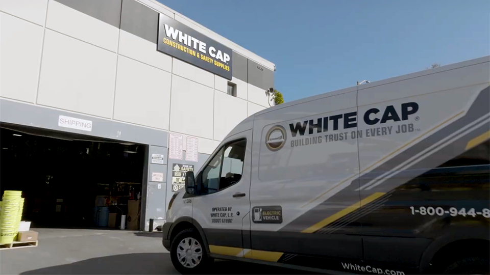 white cap van parked in front of a warehouse