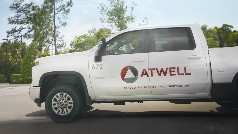 Side view image of a pick up truck with atwell group branding