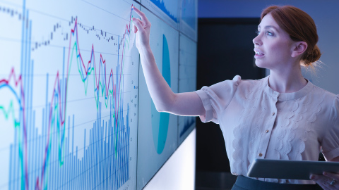 Woman looking at graphs on a screen